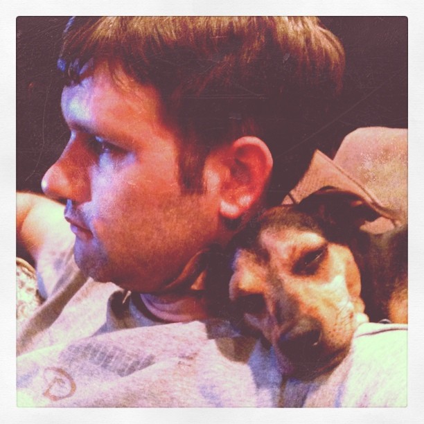 small dog resting his head on Clay’s shoulder