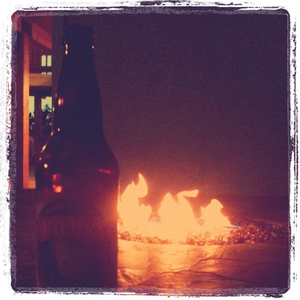 bottle of cider in front of a fire