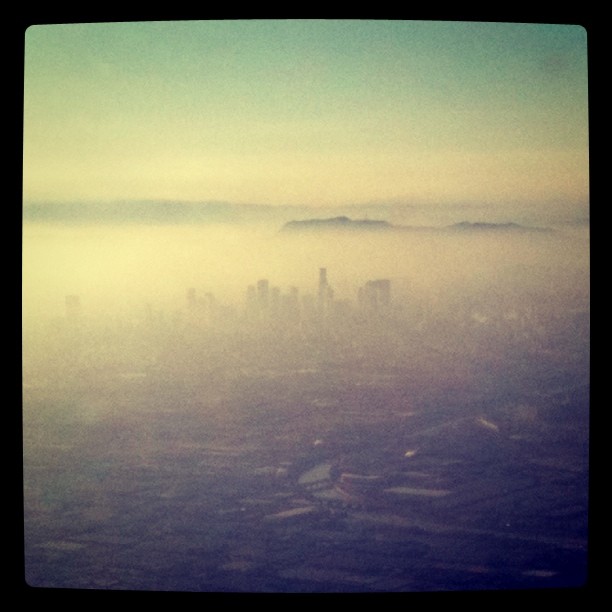 skyline peeking through some clouds from an airplane window