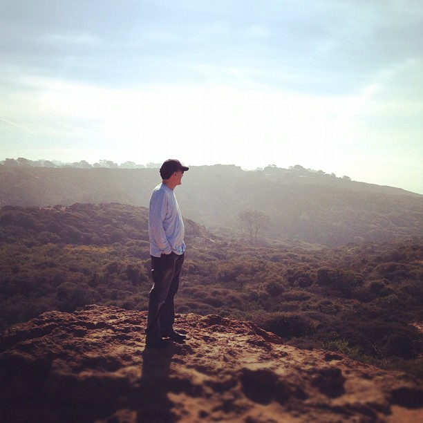 man standing on some brushy hills