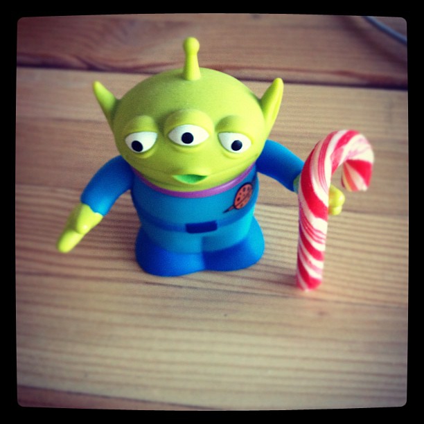 little alien from Toy Story holding a mini candy cane