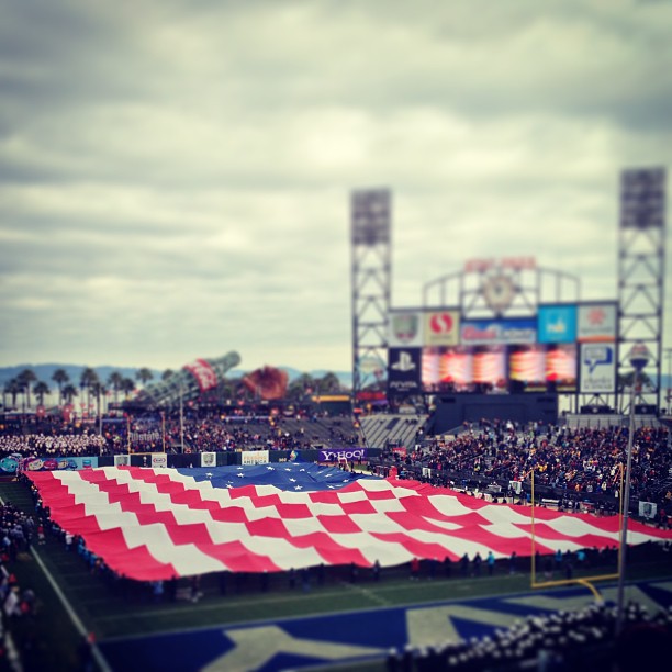 big American flag spread out over a football field