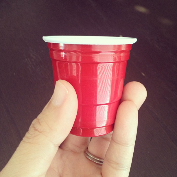 hand holding a miniature red Solo cup about the size of a shot glass