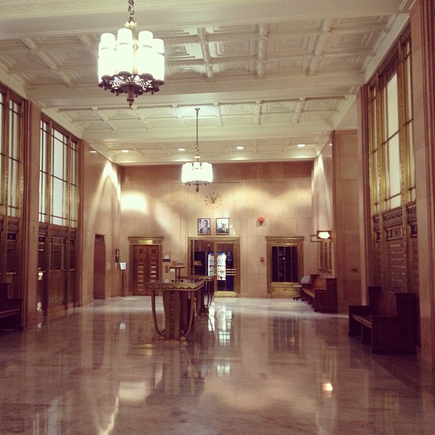 art deco style lobby with hanging pendants, shiny floors, and gold accents