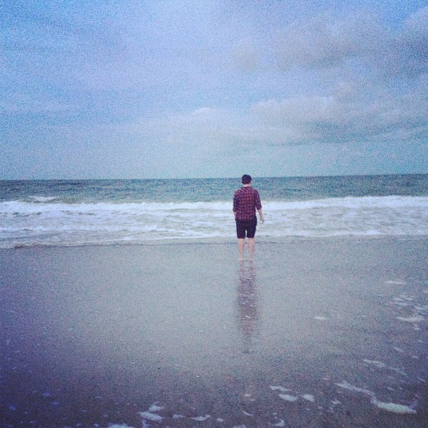 man standing barefoot on the beach