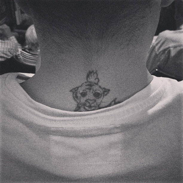 back of a guy’s neck where a tiger tattoo peeks up above his shirt collar