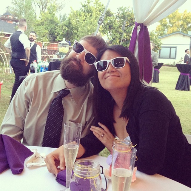 Lynn and Clay at a wedding banquet wearing matching white sunglasses