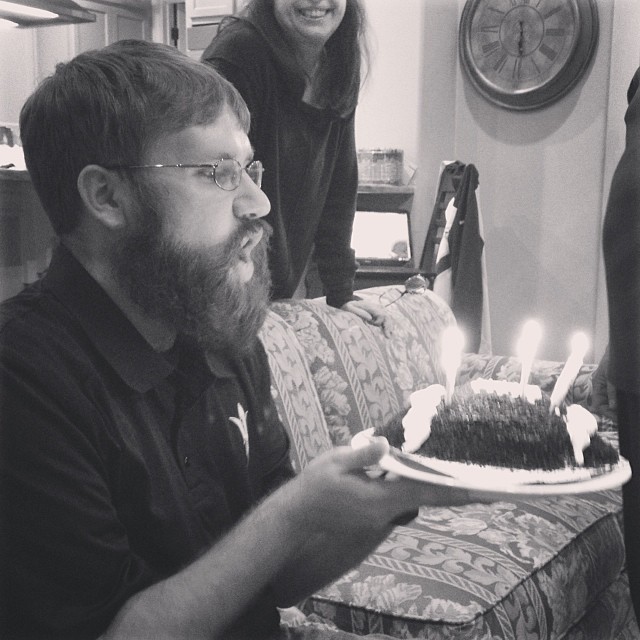 Clay blowing out candles on a football-shaped cake