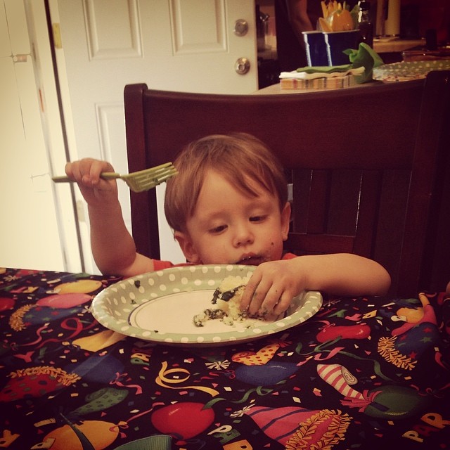 small kid eating birthday cake with his hands