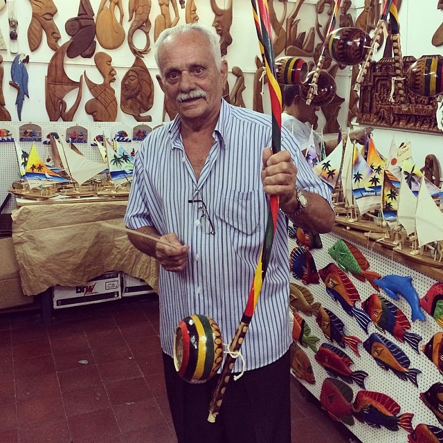 shop owner showing us a wooden musical instrument