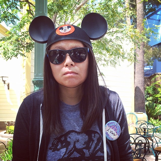 Lynn wearing Mickey ears and sunglasses but not smiling