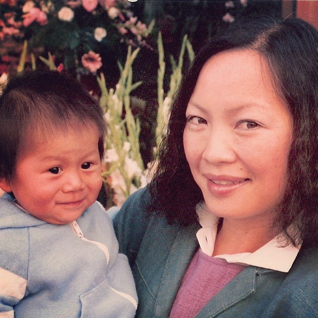 Lynn as a wee baby being held by her mom and making a face like she just pooped herself