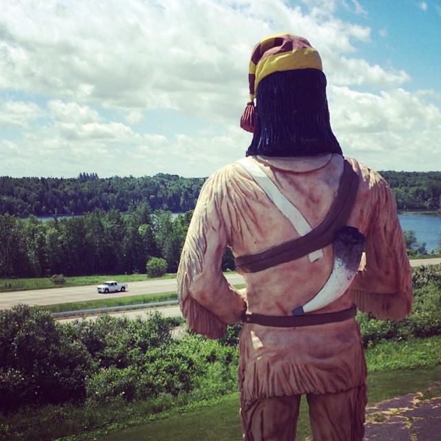 backside of a giant frontierman statue overlooking the highway