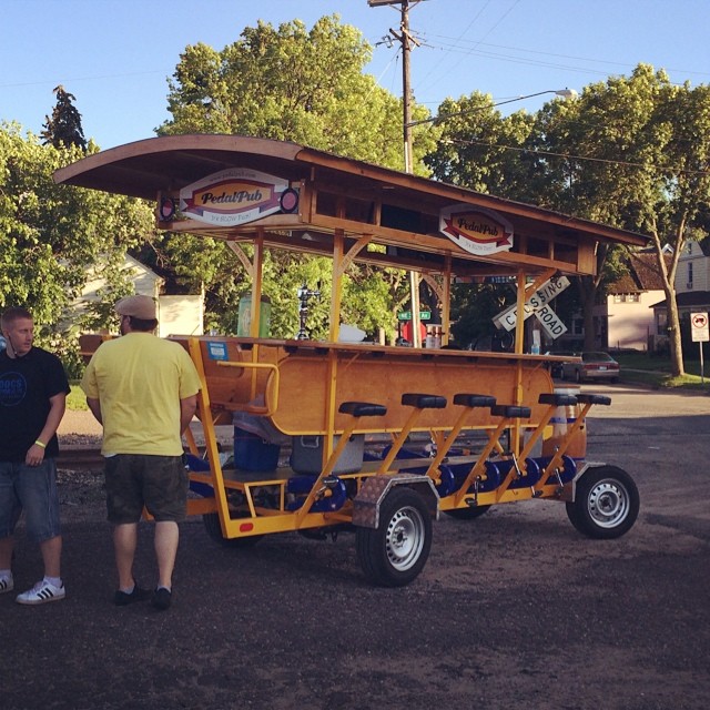 a traveling bar on wheels with rows of bicycle seats and pedals