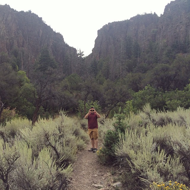 Jake on a hiking trail holding his hands up to his eyes like bionculars