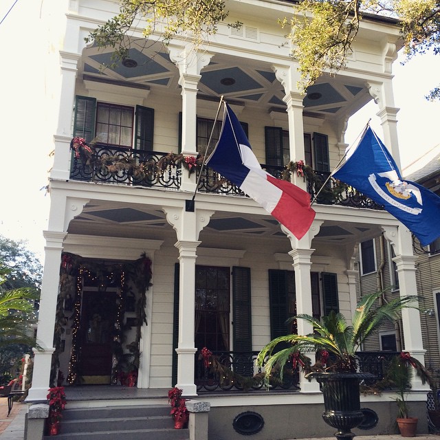 French colonial style house with French flag flying outside