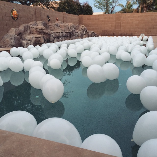 swimming pool filled with white floating balloons