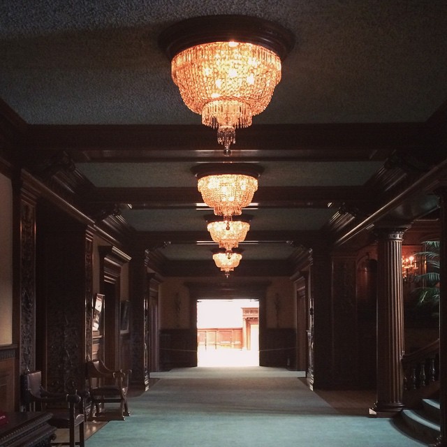 fancy old house hallway lined with chandeliers