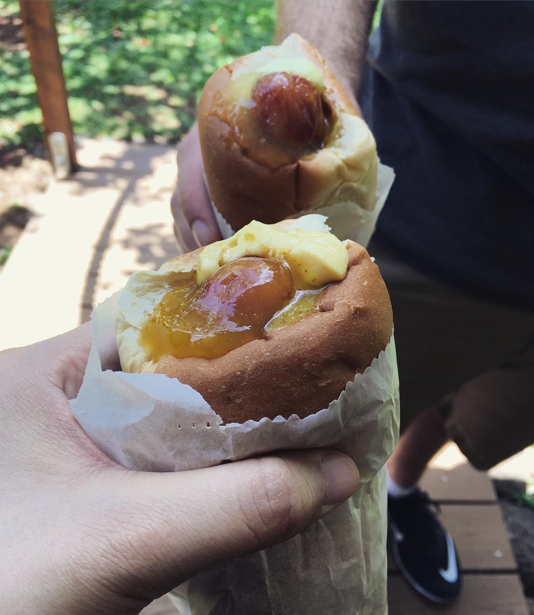 two hot dogs stuck inside Hawaiian sweet rolls with tropical fruit filling