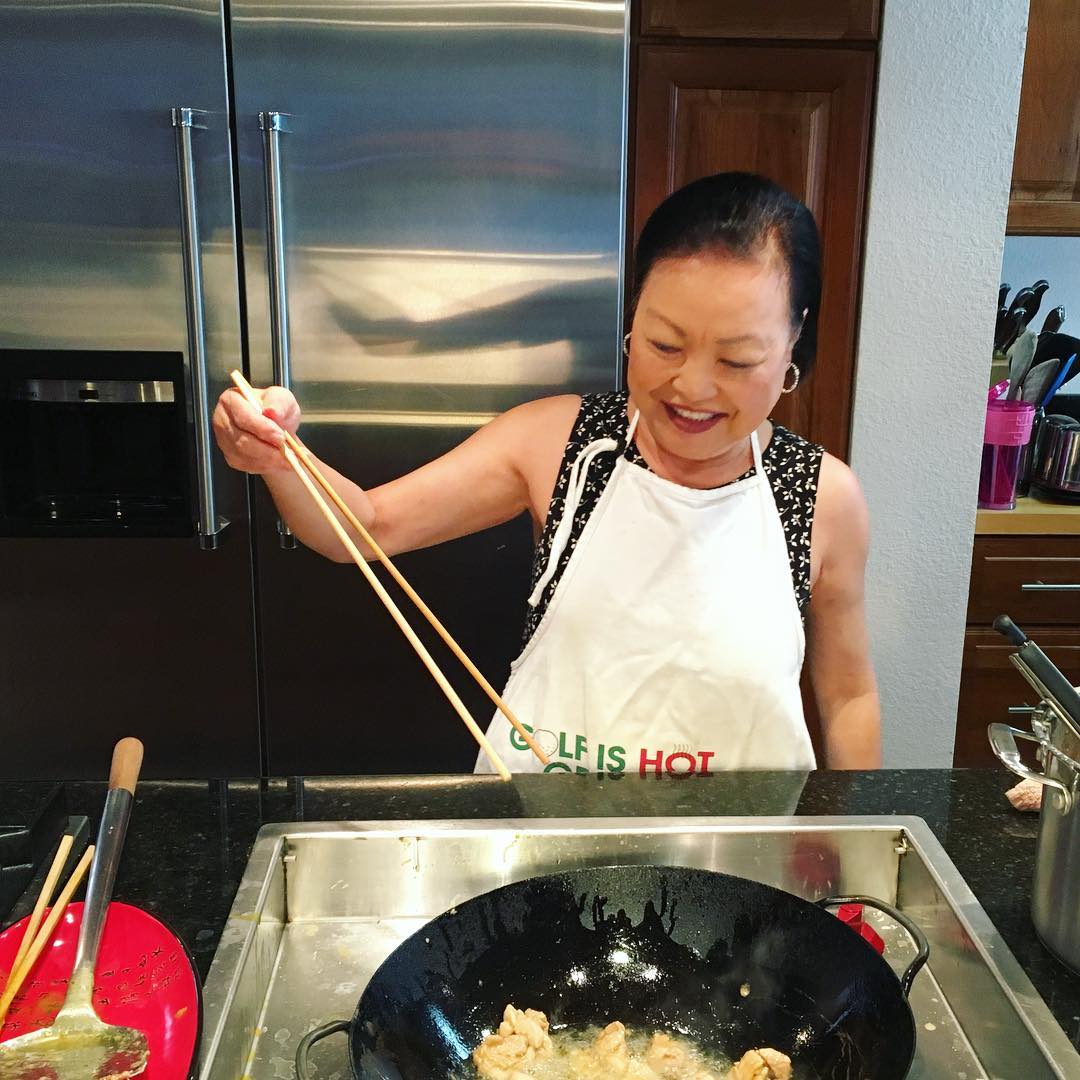 mom cooking in the wok with giant chopsticks