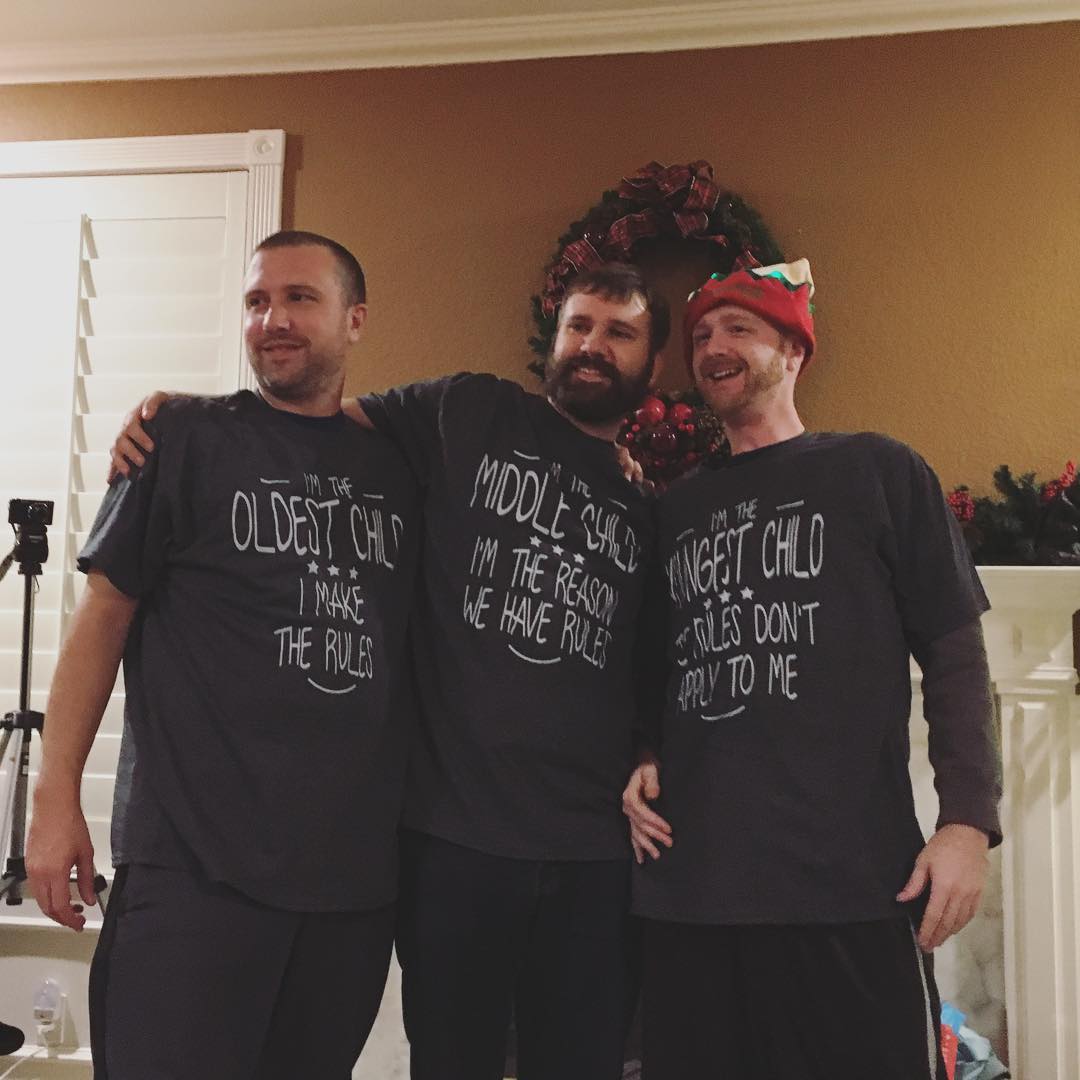 Clay, Nate, and Austin wearing t-shirts about being the oldest, middle, and youngest sibling