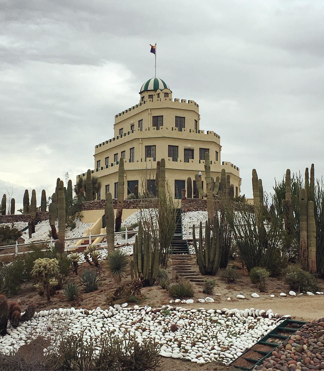 Tovrea Castle, a tiered adobe building with green and white striped cap and flag