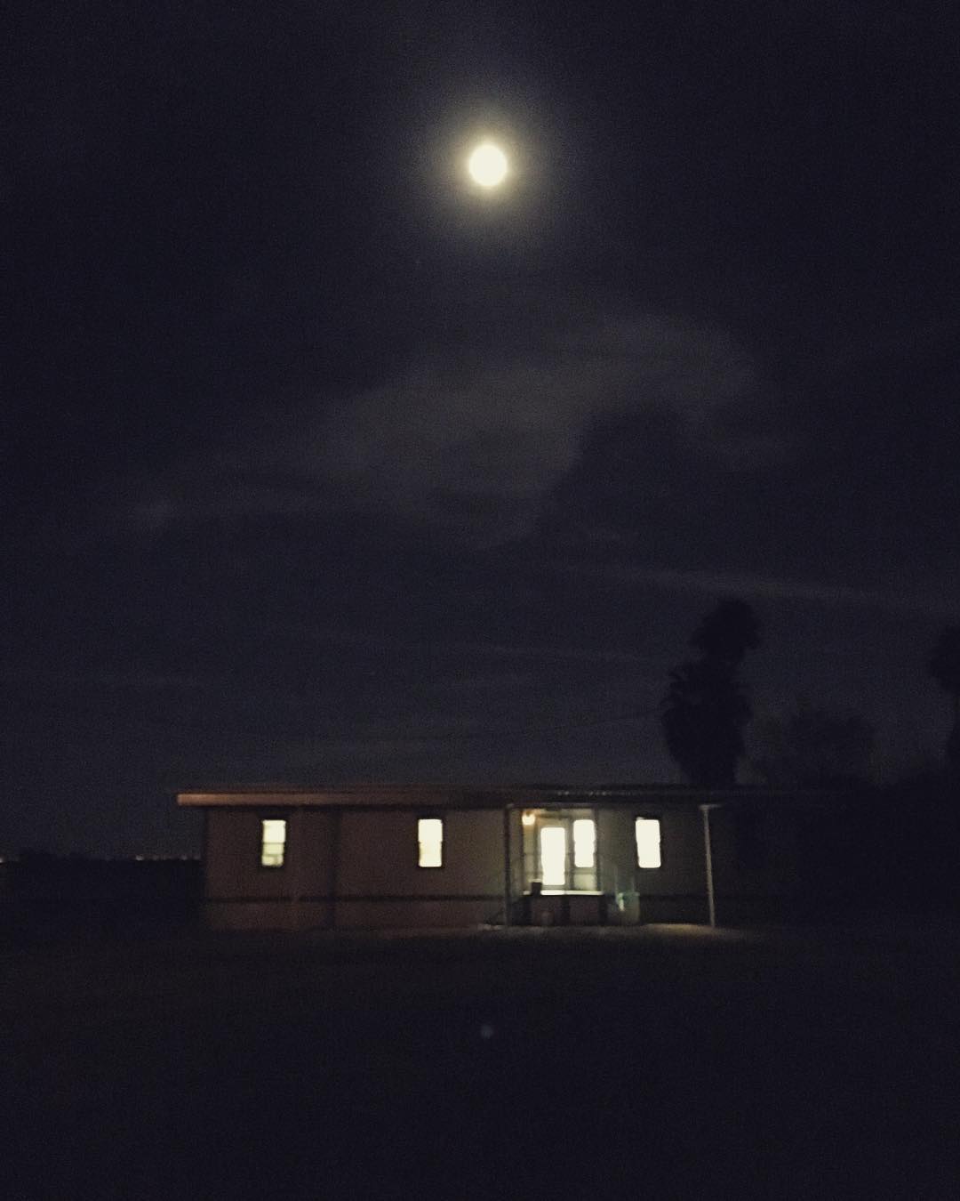 moon over a small house in the dark