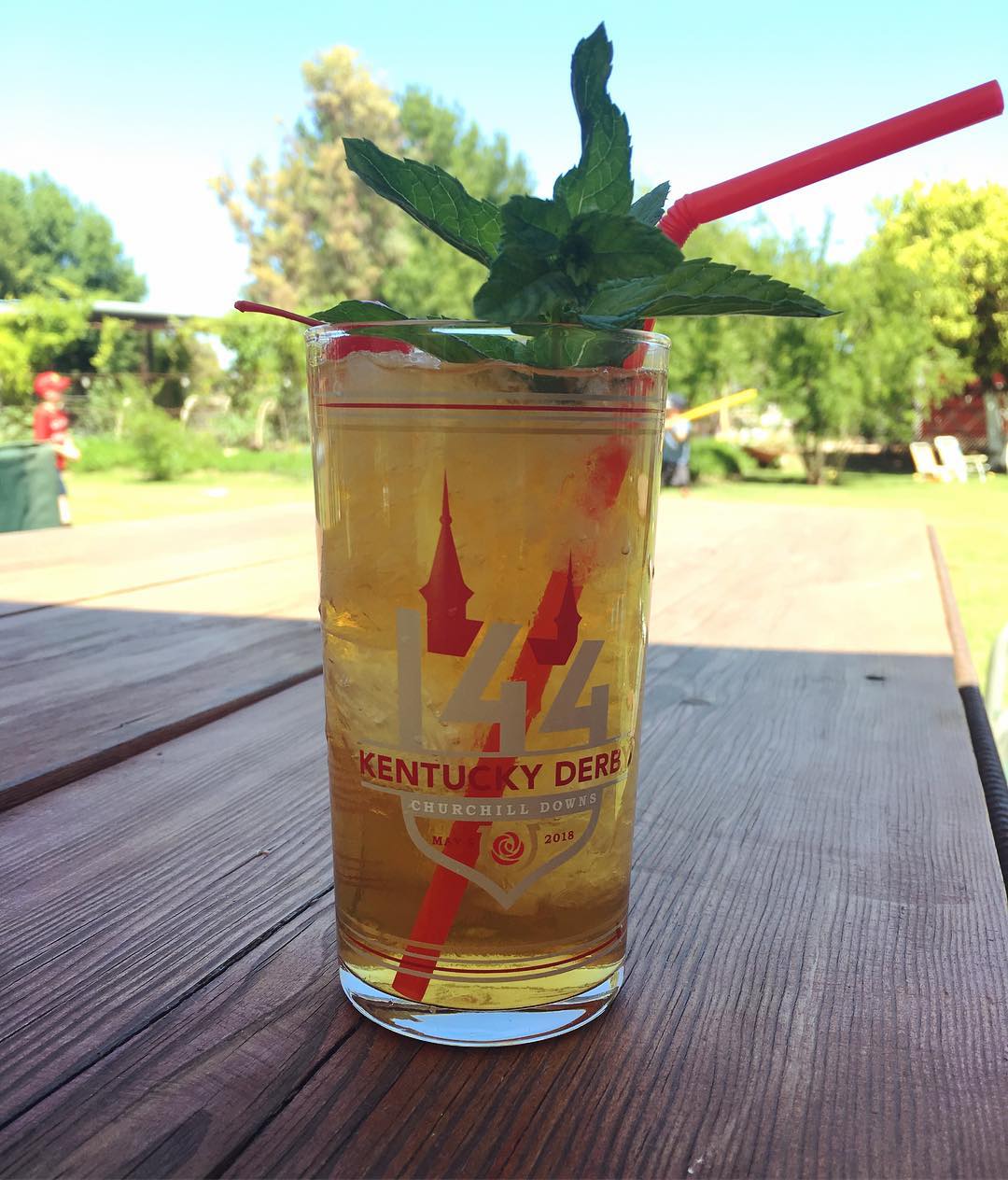 mint julep in a 144th Kentucky Derby cup; the cup is mostly clear with red and white graphics