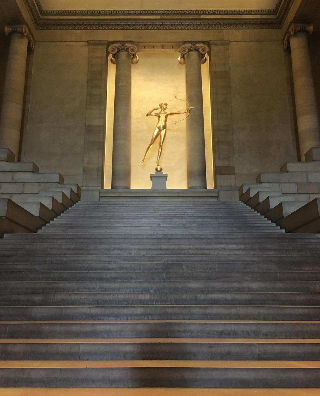 cement staircase with golden Diana statue by Augustus Saint-Gaudens