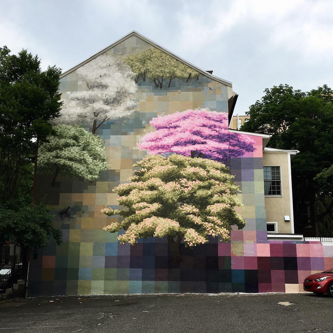 outdoor wall mural of pixelated cherry trees and down the wall the pixels get larger and larger