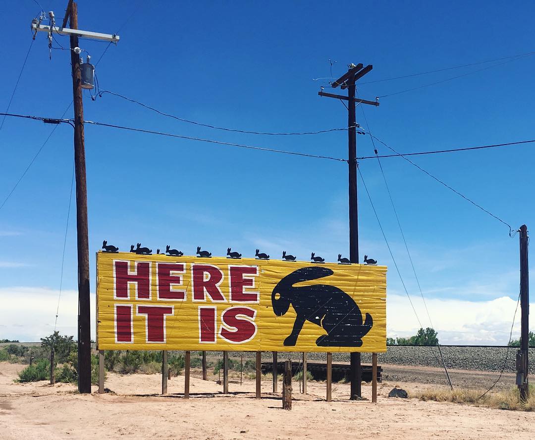 classic yellow Route66 sign of a black rabbit and the words “Here it is” in red