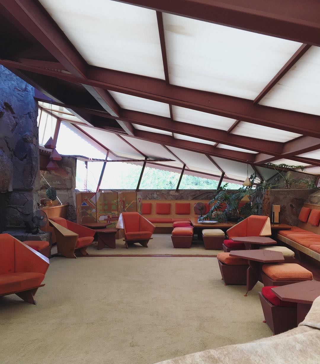 mid-century-style room designed by Frank Lloyd Wright with angled skylight ceiling and vintage furnishings 