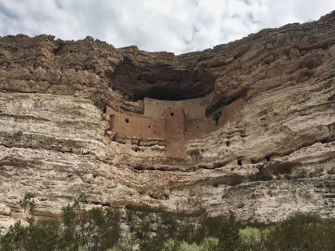 ancient structures built into a big hole on the side of a cliff