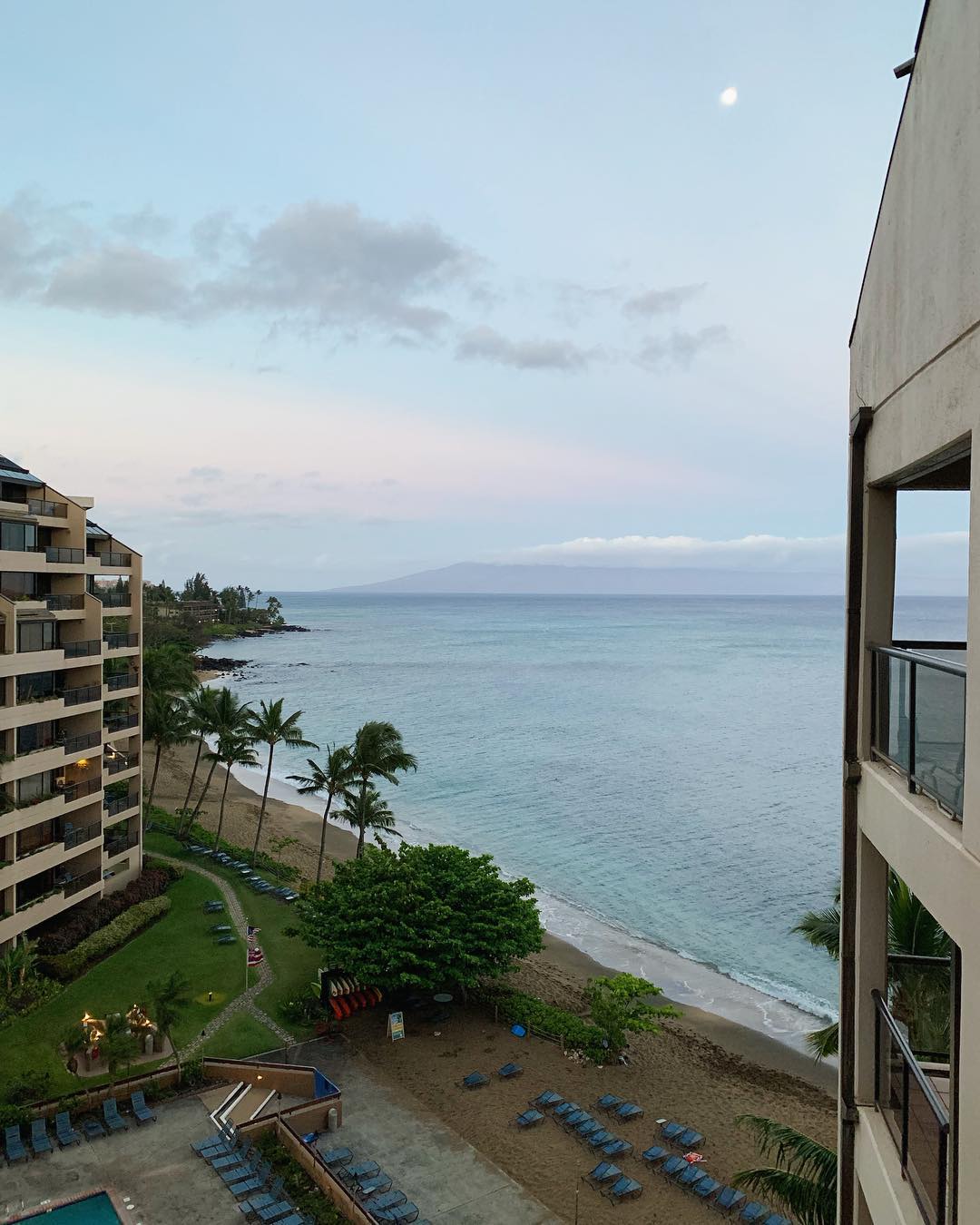 looking out a hotel balcony to a Hawaiian beach below