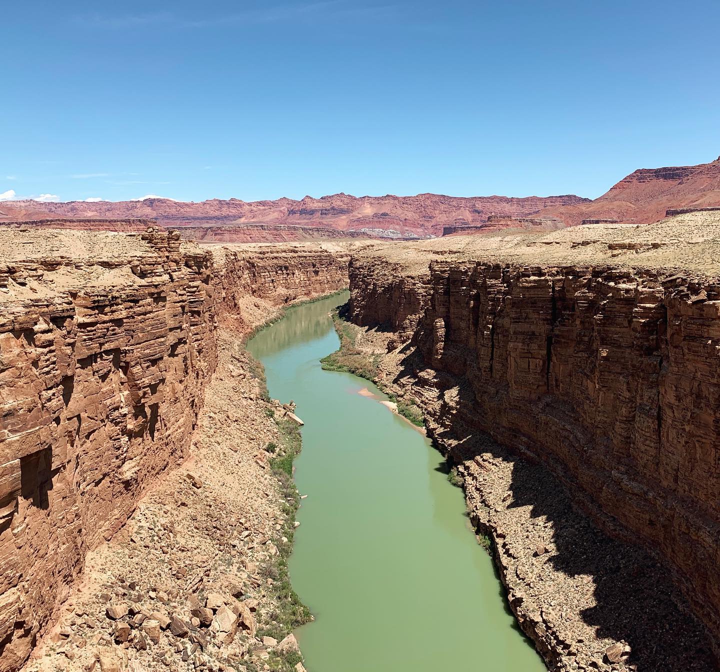 desert canyon with a green river flowing through it